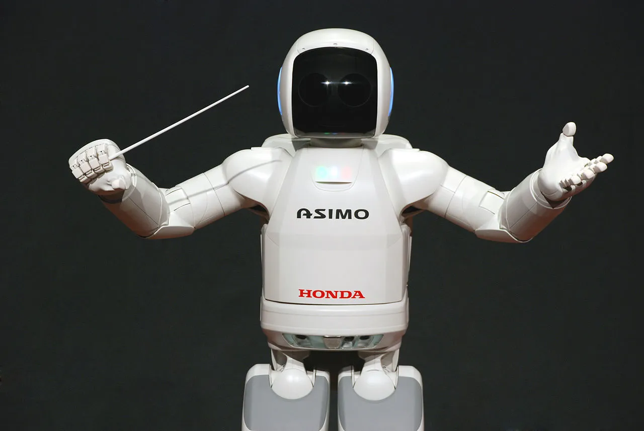 'By Vanillase (Own work) <a href="http://creativecommons.org/licenses/by-sa/3.0">CC BY-SA 3.0</a>, via <a href="https://commons.wikimedia.org/wiki/File:ASIMO_Conducting_Pose_on_4.14.2008.jpg">Wikimedia Commons</a>'